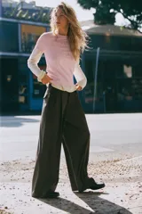 Pantalón de tiro medio con pinzas en el delantero, corte recto y amplio. Cuenta con trabillas en la cintura, bolsillos laterales y cierre frontal con cremallera, botón y gancho metálico.