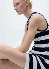 Vestido corto de tejido de punto con diseño entallado, cuello redondo y tirantes anchos. Presenta un estampado de rayas horizontales con una división vertical central que alterna la dirección y el grosor de las rayas.
