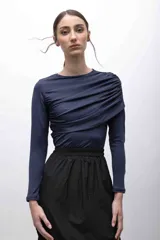 Top de jersey tricot suplex color azul marino, con mangas largas y frunces diagonales en el frente.