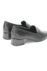 Mocasín de cuero negro liso combinado con cuero texturado en la capellada, con punta redondeada y taco medio ancho.