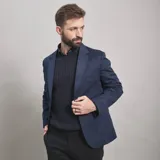 Saco de gabardina azul marino con solapa de muesca, dos botones frontales y bolsillos de parche.