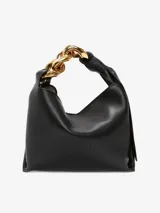 Bolso de mano JW Anderson modelo Chain Hobo Small, color negro, confeccionado en cuero. Presenta cierre magnético, logo en relieve, asa con cadena decorativa en tono dorado y un compartimento interno.