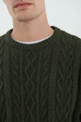 Sweater de tejido de punto color beige claro, con diseño de trenzas (aranes) en el frente y mangas de punto liso. Tiene cuello redondo.