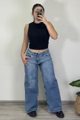 Pantalón jean celeste de tiro medio, corte ancho y estilo baggy.