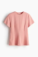 Top de manga corta color rosado, con cuello redondo y pinzas moldeadoras en la cintura que generan un bajo acampanado.