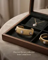 Brazalete ancho de bronce con acabado texturizado dorado, adornado con tres apliques en forma de estrella con circonias incrustadas.
