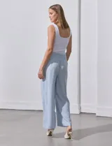 Pantalón largo de poliéster color beige con rayas verticales, pretina ancha elastizada en punto smock y pierna ancha.