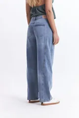 Pantalón jean gris de tiro medio, corte amplio y redondeado.