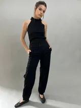 Pantalón tipo babucha confeccionado en lana de oveja, color visón. Presenta un diseño de tiro alto con textura vertical plisada a lo largo de las piernas, cintura con cierre de doble broche y puños elásticos en los tobillos.