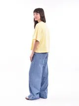 Remera oversize de color amarillo pastel, con cuello redondo y mangas cortas de corte holgado.