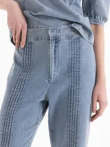 Pantalón de corte recto confeccionado en denim celeste liviano, con detalles de alforzas verticales en el frente y bolsillos plaqué en la parte posterior.
