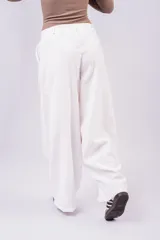 Pantalón de vestir negro de corte wide leg, con diseño de inspiración sastrera y costuras verticales frontales. Presenta un calce fluido y tiro alto.