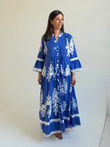 Vestido largo color azul con estampado ornamental en color blanco, escote en V con botones frontales y mangas tres cuartos con volados.