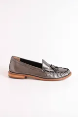 Mocasines negros de cuero con borlas y costuras decorativas.