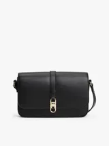 Cartera de hombro negra con solapa frontal y correa ajustable. Presenta un broche metálico dorado con el monograma TH en el centro.