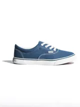 Championes de lona color azul, con cordones blancos, ojales metálicos y suela de goma blanca con detalle de línea oscura.