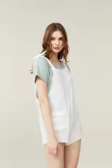 Mono corto color amarillo pastel, con breteles finos que se atan en los hombros, escote recto y dos bolsillos delanteros.