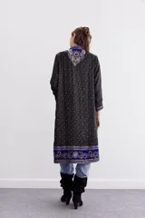 Kimono midi de satén negro con bordados de lentejuelas, mostacillas y piedras. Tiene detalles en velvet, mangas 3/4 y forro interior de jacquard. De calce recto.