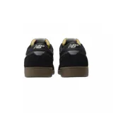 Championes New Balance NM508SBA negros con detalles en blanco y suela marrón.