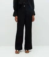 Pantalón de sastrería modelo wide leg, de tiro alto, confeccionado en tejido crepé. Presenta cierre frontal con botón y bolsillos traseros decorativos.