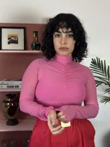 Remera de microtul elastizado color rosa, con cuello alto y detalle de fruncido central vertical.