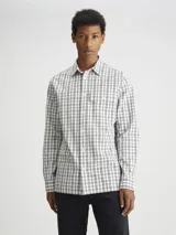 Camisa de manga larga Calvin Klein de algodón con estampado a cuadros en blanco y negro. Tiene cuello formal, cierre frontal con botones, un bolsillo con solapa en el pecho y corte regular fit.