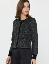 Cardigan negro de manga larga con lentejuelas bordadas, cuello redondo y cierre frontal con botones metálicos. Presenta puños y bordes acanalados.