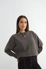 Sweater de punto negro, de corte holgado y diseño cropped, con cuello redondo y mangas largas.