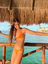 Top de bikini color lila con textura arrugada, corte triangular y tirantes finos regulables.