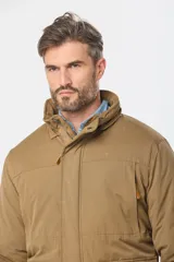 Campera color marrón con capucha desmontable, cierre frontal con cremallera y botones a presión, múltiples bolsillos con solapa y puños ajustables con botones.