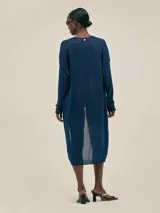 Cardigan largo azul tejido en jersey con lurex, con bolsillos en el frente y detalle en cobre con logo.