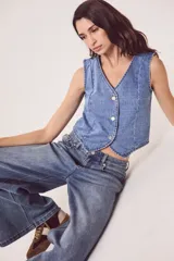 Chaleco de denim celeste con cuello en V y cierre frontal con botones metálicos.