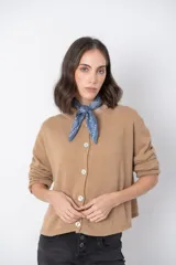 Cardigan color camel con cuello redondo y cierre frontal con botones. Tejido de lana, cashmere, acrílico y viscosa.