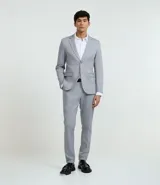 Pantalón de vestir masculino color gris claro, de corte recto y tiro medio. Presenta cintura con trabillas, cierre frontal oculto y bolsillos laterales. Confeccionado en tricolina.