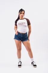 Short de denim azul índigo con tiro medio-alto, bolsillos clásicos y terminación desmechada en las piernas.
