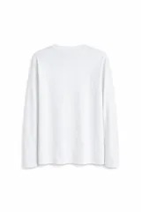 Remera de manga larga con cuello redondo, confeccionada en tejido de punto liso.