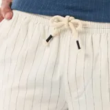 Bermuda de lino mezclado color blanco con sutiles rayas verticales oscuras, de corte clásico y bolsillos laterales.