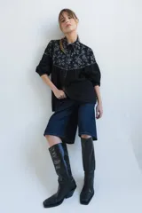 Camisa negra de manga larga con canesú estampado con diseño floral, cuello camisero y cierre frontal con botones.