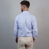 Camisa negra de algodón con cuello clásico, manga larga y cierre frontal con botones. Presenta un logo bordado en el pecho. Corte entallado.