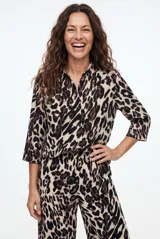 Camisa de manga larga con estampado animal print tipo leopardo, cuello camisero y cierre frontal de botones negros.