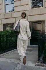 Chaqueta color tostado con cuello solapa, manga larga y cierre frontal con cremallera. Presenta bolsillos delanteros de plastrón con solapa y detalle de cintura ajustable con lazada.