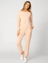 Buzo de punto color rosa, con cuello redondo y detalle de tejido crochet en el escote. Presenta mangas largas y un corte clásico con caída suave.