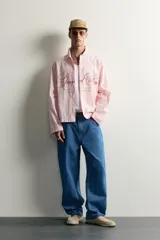 Jeans loose fit de tiro medio, confeccionados en denim de algodón color azul con efecto lavado. Presentan diseño de cinco bolsillos, bolsillo plastrón estilo carpintero en la pierna y cierre frontal con cremallera y botón.