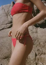 Top de bikini rojo con apliques metálicos.