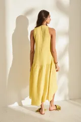 Vestido midi negro sin mangas, con cuello redondo, corte recto en la parte superior y falda amplia con vuelo. Presenta costuras decorativas verticales y un detalle deshilachado en el dobladillo inferior.