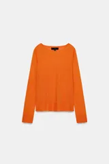 Jersey de punto liso, color azul brillante, con cuello redondo y manga larga. Presenta acabados en rib en puños, cuello y bajo, con aberturas laterales en el ruedo.