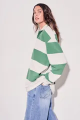 Sweater estilo polo de corte oversize, con diseño de rayas horizontales anchas en tonos camel y bordó. Presenta cuello camisero con cierre frontal parcial y mangas largas con puños ajustados.