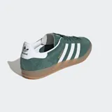 Championes Adidas Gazelle Indoor color verde con las tres tiras blancas y suela de goma color caramelo.