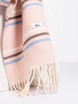 Bufanda de tejido suave en color marrón chocolate con diseño de rayas horizontales en tonos naranja, beige y gris. Presenta terminaciones con flecos en los extremos.