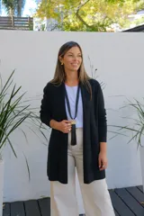 Saco abierto de punto color negro, con mangas largas y bolsillos frontales. Diseño de corte recto y largo medio.